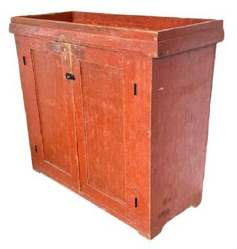 L132 Tall Pennsylvania mid-19th century Drysink bearing original red painted surface. Unique configuration features open well with applied chamfered molding around the base of the well over two doors that open to a clean, natural patina with shelving for added storage, resting on cut out feet. The wood is pine with square head nail construction. Circa 1850s. Measurements: 44 ½ wide x 18 ¾ deep x 39 ½ tall.   