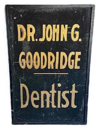 K1866 Single sided wooden Trade Sign that reads: "Dr. John G. Goodridge - Dentist". The lettering is hand painted in gold gild on a black sand-painted background with applied black painted molding surrounding all sides. Circa 1900. Measurements: 23 ¾” wide x 1 ½” thick x 36 ¼” tall.