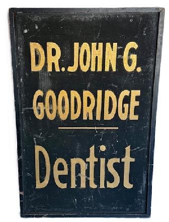 K1866 Single sided wooden Trade Sign that reads: "Dr. John G. Goodridge - Dentist". The lettering is hand painted in gold gild on a black sand-painted background with applied black painted molding surrounding all sides. Circa 1900. Measurements: 23 &frac34;� wide x 1 &frac12;� thick x 36 &frac14;� tall. 
