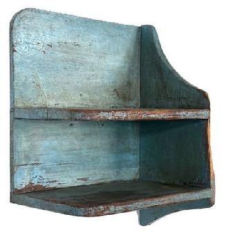 **SOLD** L26 Unique, late-19th century Hanging Shelf bearing old original blue painted surface. The configuration of this shelf lends itself to the possibility of being hung in a corner as it has a shaped solid end on the right side; whereas the left side is open ended with nicely rounded corners on each shelf. Wear to the right end. The wood is pine  with a combination of square head nails and wire nail construction. Measurements: 21 wide x 12 deep x 21 tall on left side x 26 ¼ tall on right side.  