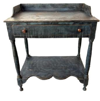 M94 Early 19th century New England Sheraton blue paint decorated open Washstand bearing original blue painted surface with black smoke decoration. Features an applied dovetailed gallery with shaped ends, a full-sized dovetailed drawer, a shelf below with a decorative shaped front edge and turned legs. All original. Square head nail construction. Circa 1820s-1840s