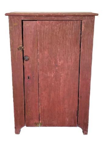 K1614 Mid 19th century Maryland one door storage cupboard bearing original red painted surface resting on high cut out feet. Square head nail construction. Clean natural patina interior with shelves for added storage options. The wood is pine. Circa 1850s. Measurements:  32 &frac12;� wide x 18� deep x 49� tall.   