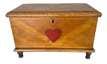 **SOLD** SB24 Exquisite early 19th century miniature Pennsylvania paint decorated blanket chest retaining its original overall mottled and stripe mustard paint decorated surface with a central heart in red paint. Six board, finely dovetailed construction with square head nails securing the bottom. Molded edges surround the top and bottom. Clean, natural patina interior with lidded til inside. The wood is pine with applied turned walnut feet. Circa 1820s. Measurements: 14 ½ wide x 7 ¼ deep x 9 tall.