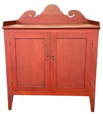 M25 Early 19th century original red painted Pennsylvania Server with applied dovetailed gallery featuring a tall, decoratively cut out backsplash with applied molding across the front of the top. Both doors are fully mortised and open to reveal a very clean, natural patina interior. The chamfered cut to the edges of legs give the appealing visual appearance of being splayed legs with the 8 ¼ clearance below. Circa 1800 1820s. The wood is pine, with square head nail construction. Measurements: 41 ¼ wide x 24 ¼ deep x 50 ½ tall (center of back).