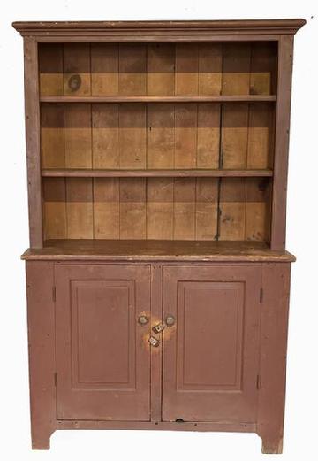 H95 Early 19th century Pennsylvania one piece open top stepback cupboard in dry, original red painted surface featuring open shelves over two beautiful, raised panel doors. Upper shelves boast double beaded edges along the front. The two fully mortised and pegged doors are raised panel inside and out and open to a clean, natural patina interior with shelf for added storage.  Applied molding around top. Half-moon cut outs on ends. Square head nail construction. Measurements: 49 ½ wide x 76 tall. It is 17 ¾ deep at waist and 13 deep at top molding.