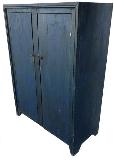 E562 Early 19th century two door storage Cupboard, original indigo blue paint, two plank doors, with picture frame molding applied to front of case, one board construction the wood is white pine, with three shelves interior, four counting the bottom. Natural wood interior, nice and clean, back boards are held on with square head nail nice high cut out feet Measurements are: 41 1/4" wide x 56" tall x 19" deep