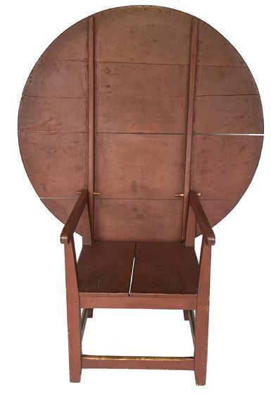 K251 19th century New England Chair Table, with the original red paint. The four-board pine top with generous overhang allows for comfortable seating. The chair base consists of a simple design that is fully mortised and pegged. Circa 1820s. Top measures 47 ¼ x 46 ¾ and it is 27 ¾ tall. (It measures 60 ¾ tall with the top in the up/stored position). The base measures 22 ¼ wide x 26 ¾ deep.