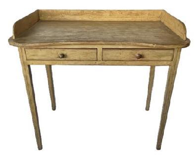 K1810 19th century Pennsylvania original mustard painted pine table with two drawers and shaped top with gallery resting on tall, delicately tapered Hepplewhite legs. Painted surface retains remnants of original black pinstripe decoration throughout. Square head nail construction with apron being fully mortised into the legs. Measurements: 37 ¼ wide x 21 deep x 33 ½ tall (back) x 30 ¾ tall (front). Apron to floor is 25.