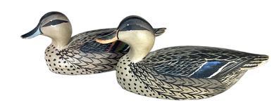 K1679 Two miniature duck decoys carved by Oliver �Tuts� Lawson (1938- ) of Crisfield, Maryland. One is a miniature Mallard Hen (8 &frac14;� long x 3� wide x 3 &frac12;� tall) and the other is a miniature Pintail Hen (8 &frac14;� long x 3� wide x 3 &frac14;� tall). Both are balsa wood bodies with slightly turned heads and original painted surfaces. Paper label from the Duck House, Rumbley, Maryland remains intact on the underside of Pintal.  