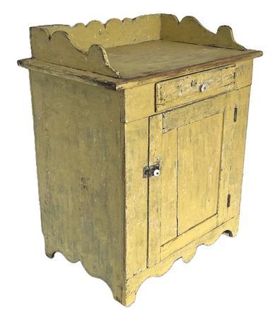 K158 19th century Pennsylvania original yellow painted Wash Stand with one drawer over one door configuration with an applied scalloped gallery on top resting on a decoratively cut out apron / ends. Square head nail construction with dovetailed gallery and mortised panel door. Clean, natural patina interior with shelves for additional storage. The wood is pine. Circa 1860s-1870s.  Measurements: 28� wide x 18� deep x 32 &frac12;� tall (back, with gallery) x 28 &frac12;� tall (front).  
