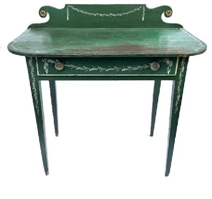 L127 19th century Country Hepplewhite Dressing Table bearing original green painted and white decorated surface featuring a scrolled backsplash and wide, dovetailed drawer and resting on tall gracefully tapered Hepplewhite legs. The wood is pine  and it is constructed with wooden pegs and cut nails. Measurements: 36 wide x 19 deep x 34 ¾ tall (back) x 29 ½ tall (front).  Clearance from apron to floor is 23 ¾.  