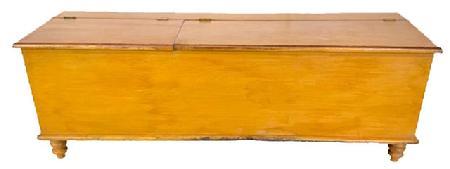 H921 Early 19th century Lancaster County, Pennsylvania mustard painted split lid wood box resting on turned feet. Rounded edges surround top and bottom. Dovetailed case. Divided interior with clean, natural patina. One board construction. The wood is pine. Circa 1820. Measurements: 72 ¾” wide x 19” deep x 21 ¼” tall.