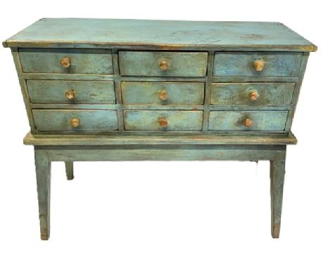 **SOLD** M129 Unique two-piece 19th century Pennsylvania nine drawer apothecary on stand in old blue painted surface with original knobs. Dovetailed drawers with mortised drawer stretchers. A few of the drawers retain divided interiors. The wood is pine with square head nail construction. Measurements: 34 5/8 wide x 13 ½ deep x 29 ¾ tall. (Apron to floor measures 14.)