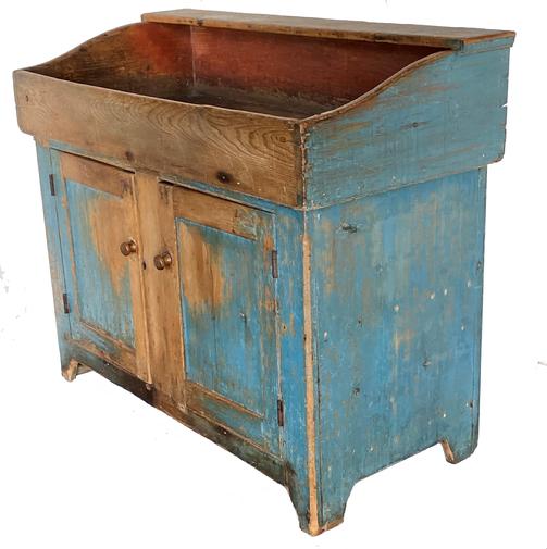 F182 Gorgeous 19th century Lancaster County Pennsylvania Dry sink with its original blue paint! Rare form having a lift off dovetailed case well with down slopping sides. The interior of the well retains its original bittersweet red paint. The bottom case has two paneled doors which are full Morisot and pegged with both of its original wooden fingered knobs! Single bedded edge around doors also on well. measurements. 43” wide. 22” deep 37 /2” tall