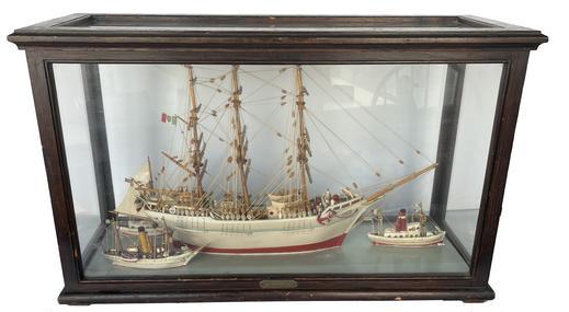 K1636 Late 19th century � early 20th century very intricately detailed Folk Art Ship Diorama in Showcase with a three masted ship in the center, surrounded by three smaller boats. Ship is flying an American Flag, an Italian pennant, and a pennant bearing the Ship�s name, �MARY�. The smaller steamboats are also flying both American and Italian flags/pennants. The single masted ship in full sails boasts a large letter �P� on its main sail and is flying an American flag. The case does not open. Boats inside appear to be made of wood with cloth/fiber rigging and sails. Engraved metal plate attached on front of showcase reads �A. Palisi Sr.� Case Measurements: 30 &frac34;� wide x 12� deep x 19� tall.  