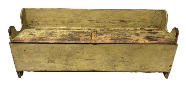 M278 Early 19th century Pennsylvania Settle / Wood Box circa 1800-1820 bearing old mustard yellow painted surface with double lift lids, a raised back, lollipop cut out and shaped ends resting on half-moon cut out feet. The wood is pine with T nail and square head nail construction. Great wear from years of use. Measurements: 72 wide x 17 ¾ deep x 30 tall (back) x 19 ¾ tall (front).