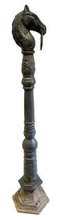 M1137 19th century cast iron Hitching Post on its original post from an estate in Chestertown MD. upright fixture with a top ring for tying horses, often ornately designed and made by foundries during the height of horse drawn transport. In the 1800s, hitching posts were essential for securing horses in front of homes, inns, churches, and public buildings. oxidation with remnants of early black painted surface. Overall height is 53 ¼ tall, with the portion that would be seen once base is buried, being 46 ½ tall. The head measures: 8 deep x 4 3/8 wide x 9 ¼ tall.