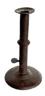 L372H Early 19th century Hog Scraper Wedding ring / band Candlestick. No evidence of ever having a finger curl at the top. Working push-up tab is unmarked. Sturdy sheet iron construction with metal wedding band. Dark, natural surface. Circa 1800-1820. Measurements: 4" diameter base x ~7 ½ tall.